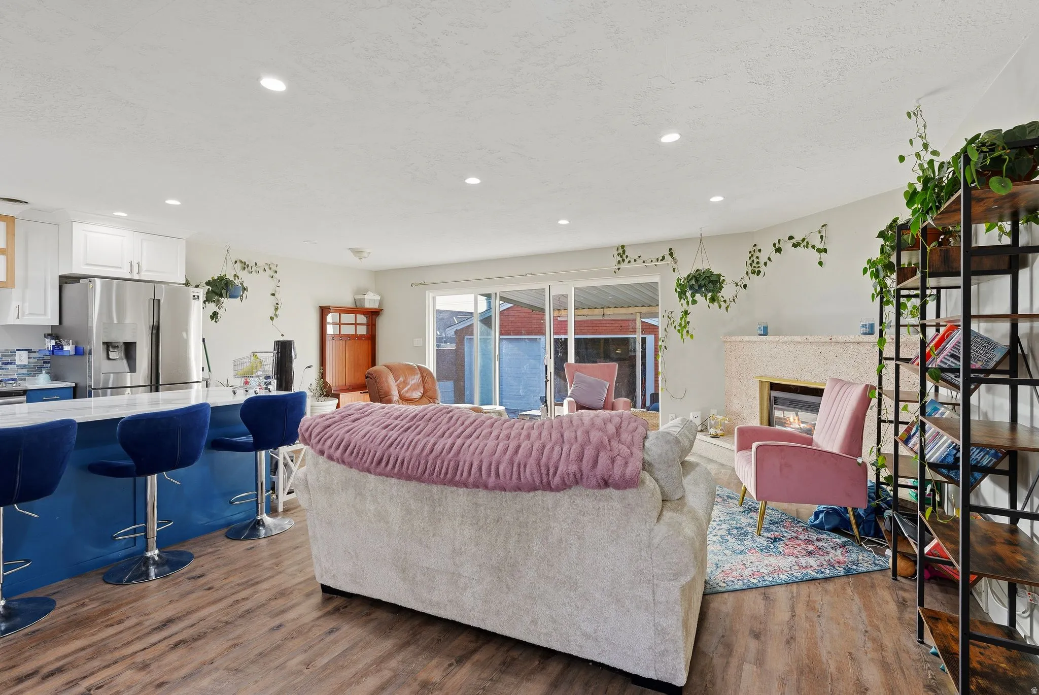 Living area featuring wood finished floors, a glass covered fireplace, and recessed lighting
