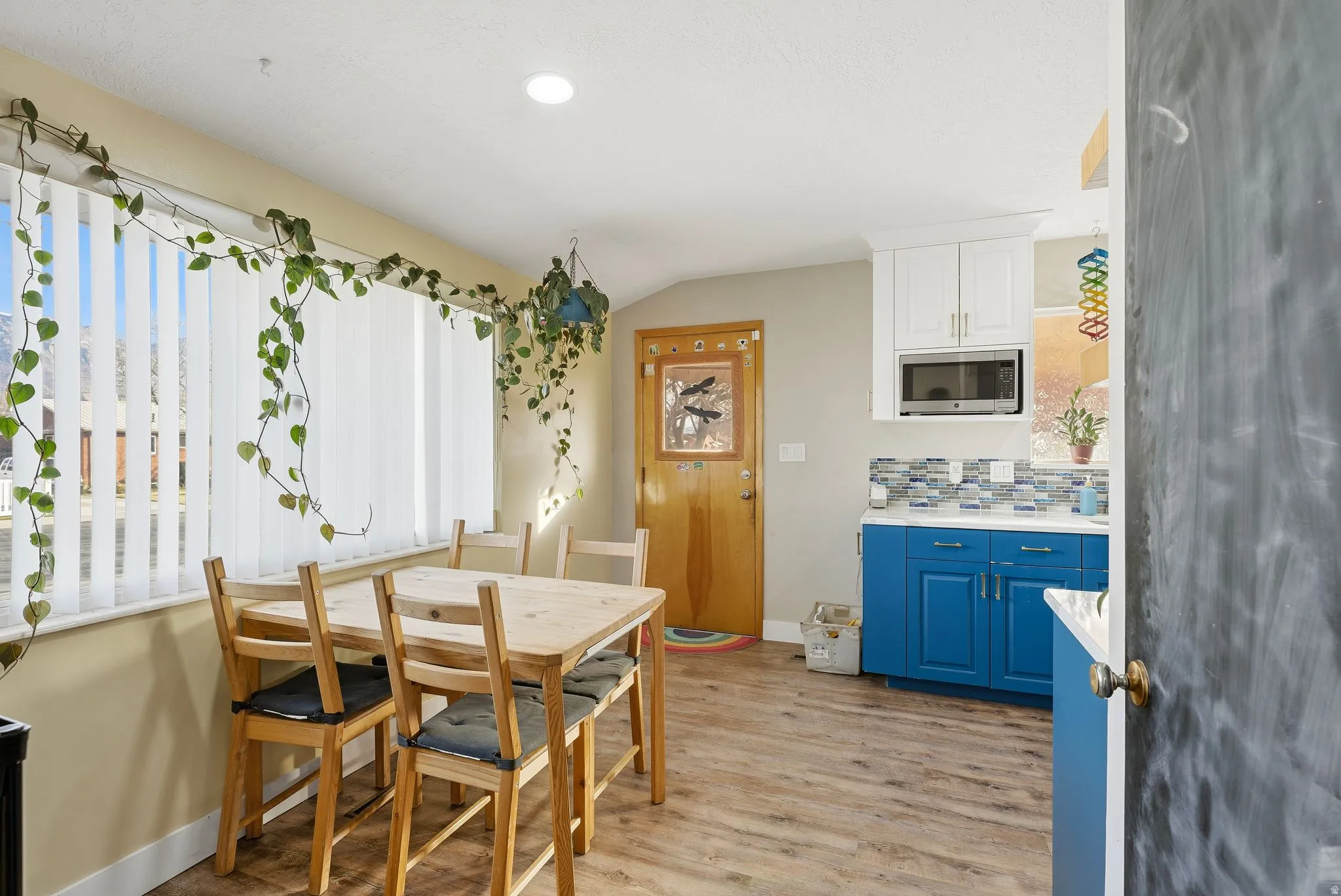Dining area featuring light wood-style flooring and vaulted ceiling