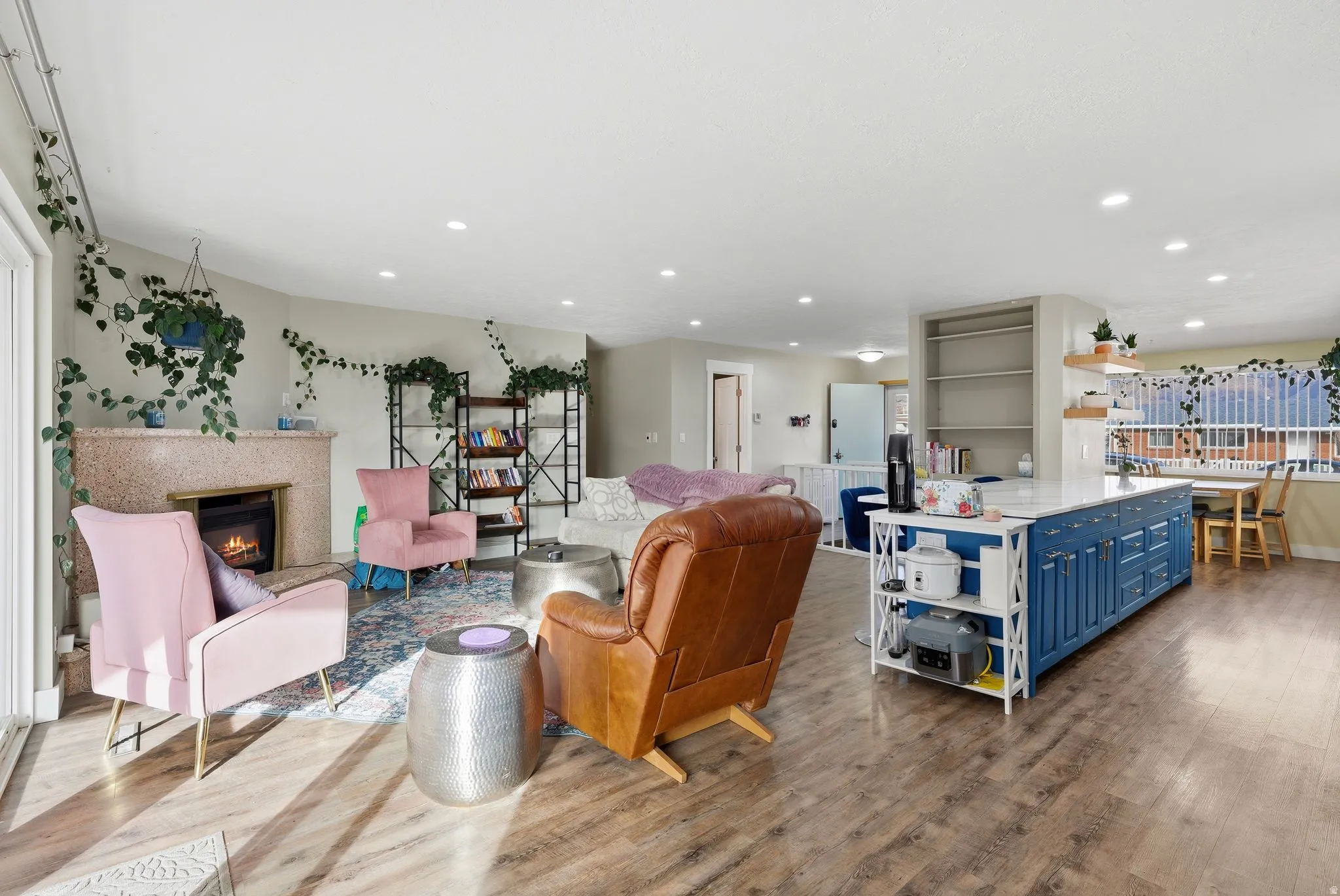 Living room featuring a glass covered fireplace, wood finished floors, and recessed lighting