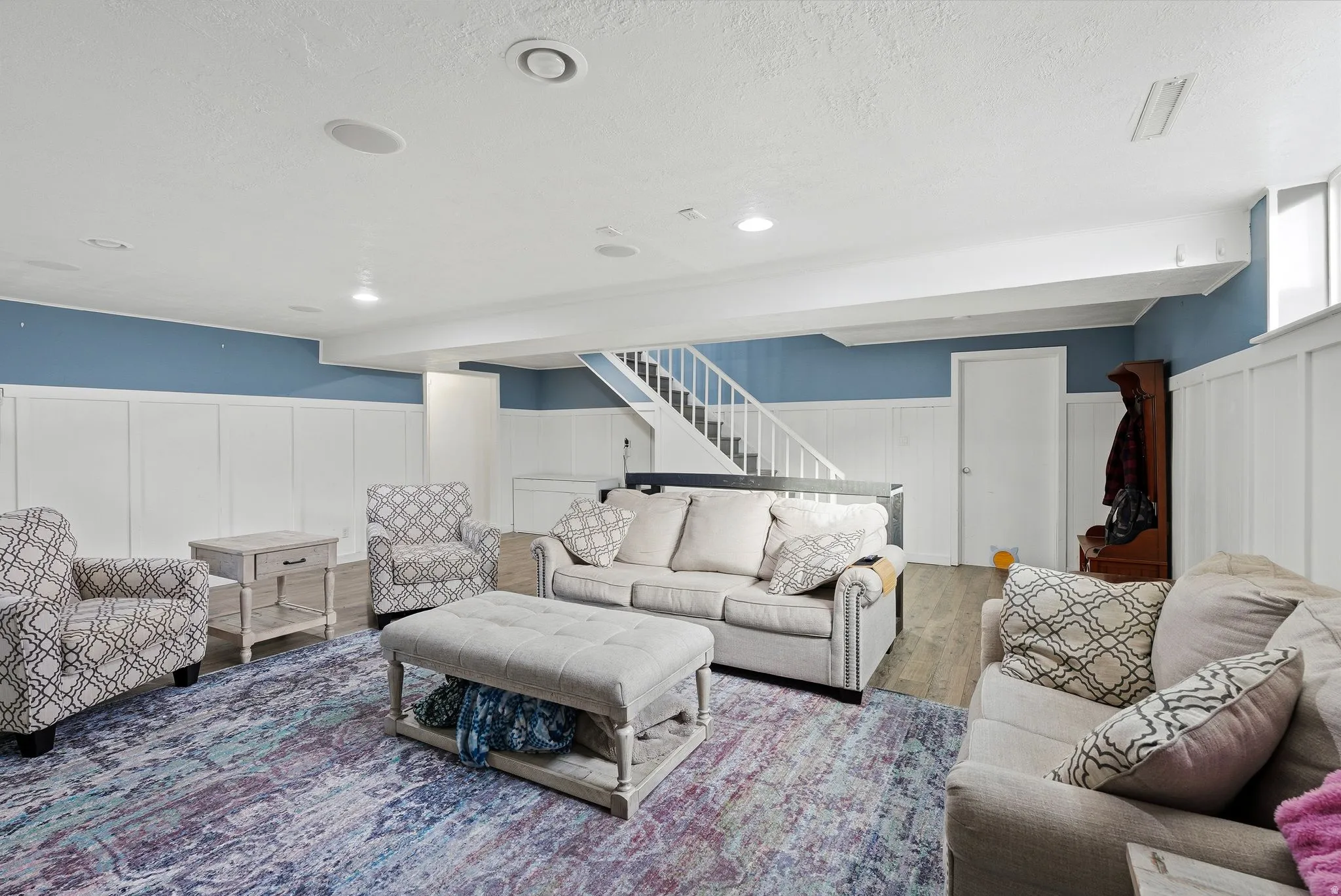 Living area with wainscoting, wood finished floors, and a decorative wall
