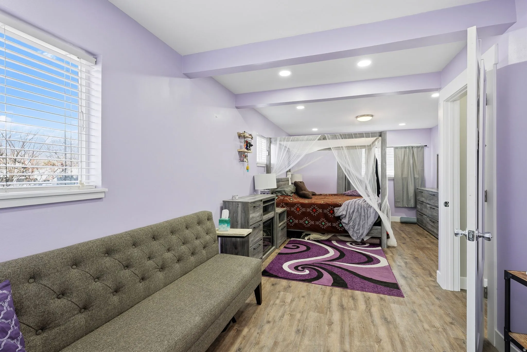 Bedroom featuring light wood-style floors, beam ceiling, and recessed lighting