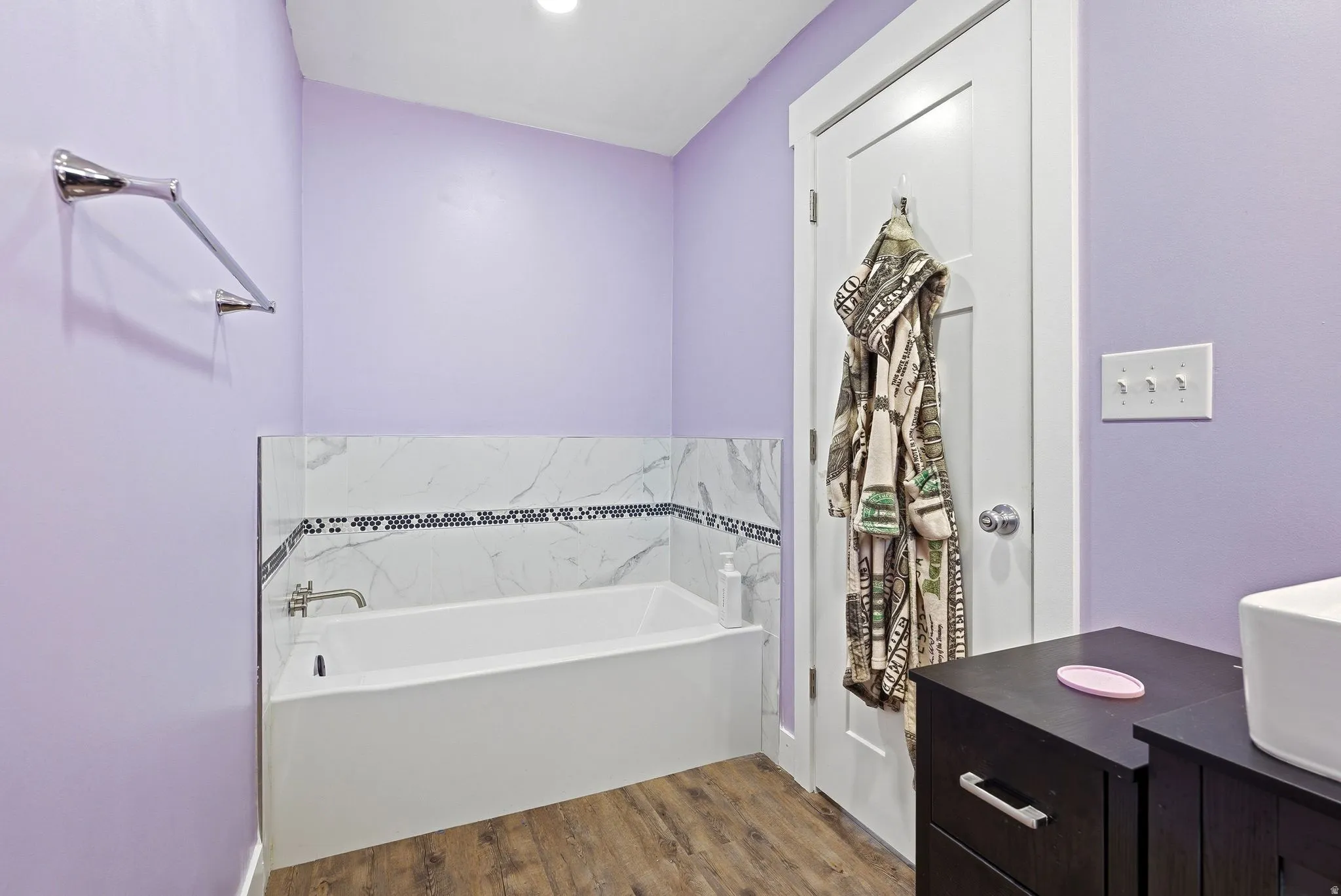 Full bath with a bath, vanity, and light wood finished floors