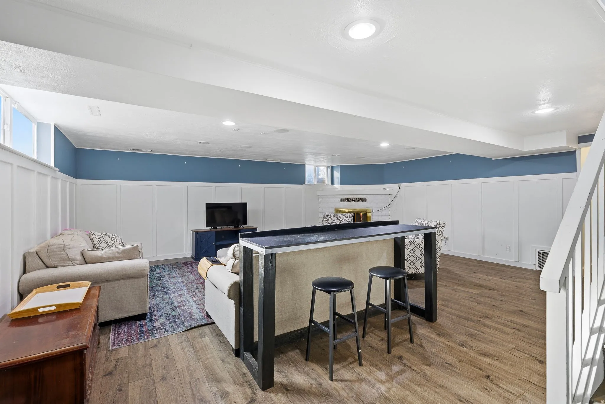 Living area with a decorative wall, wainscoting, and wood finished floors