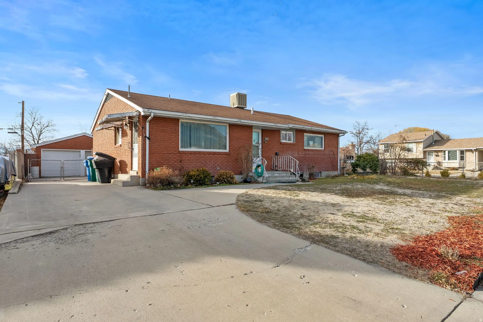 View of front facade featuring an outdoor structure, brick siding, and a garage