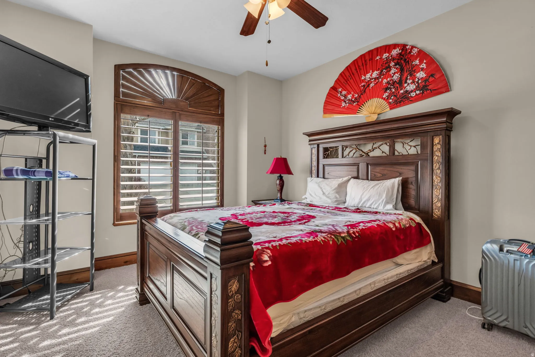 Carpeted bedroom featuring a ceiling fan and baseboards