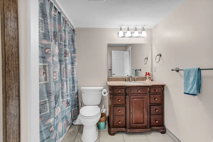 Bathroom with vanity, a shower with curtain, light tile patterned floors, and a textured ceiling