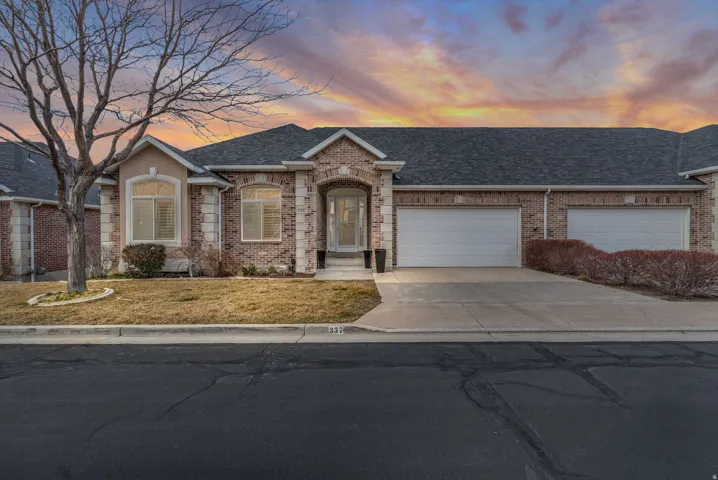 Single story home with brick siding, a shingled roof, driveway, an attached garage, and a lawn