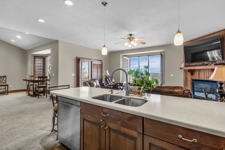 Kitchen with stainless steel dishwasher, a fireplace, pendant lighting, and open floor plan