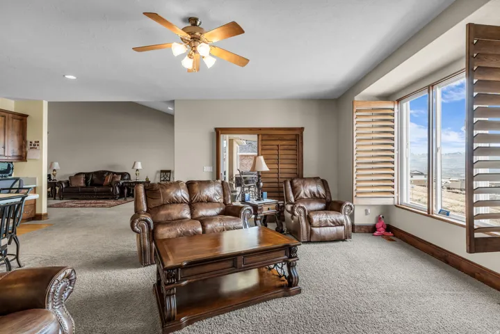 Living area featuring light colored carpet and a ceiling fan