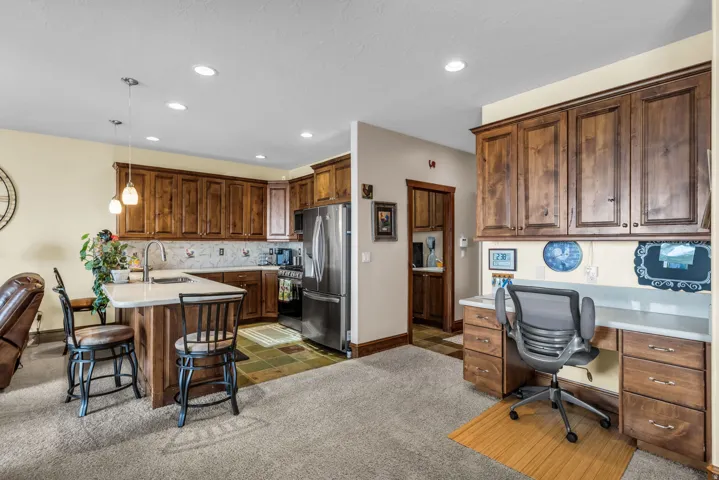Office space with recessed lighting and dark colored carpet