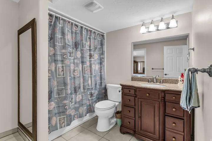 Bathroom featuring vanity, light tile patterned floors, and shower / bath combo