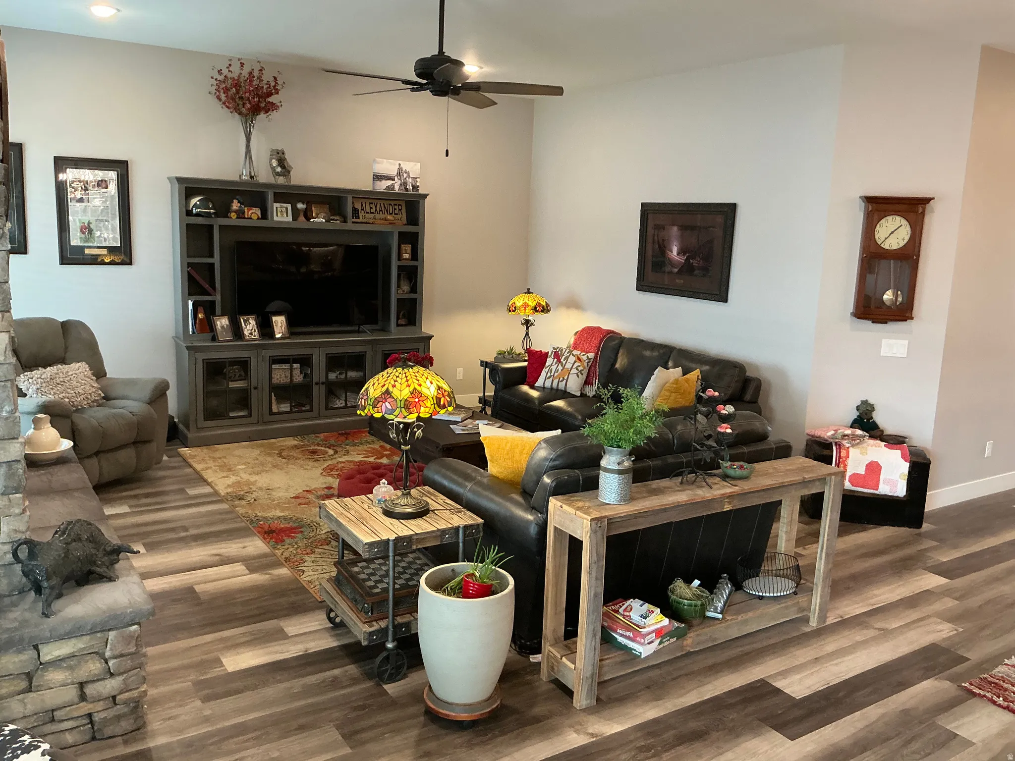 Living area with dark wood-type flooring and a ceiling fan