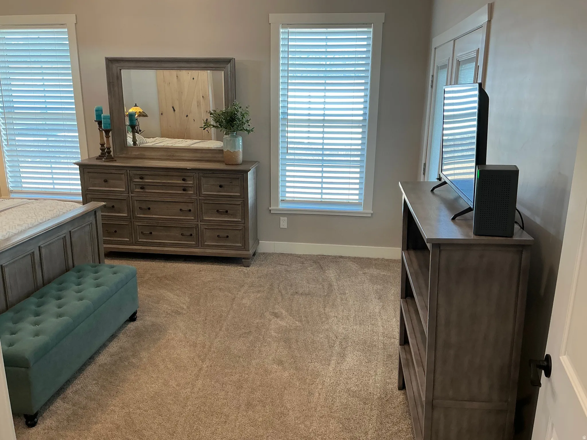 Bedroom with multiple windows and light colored carpet