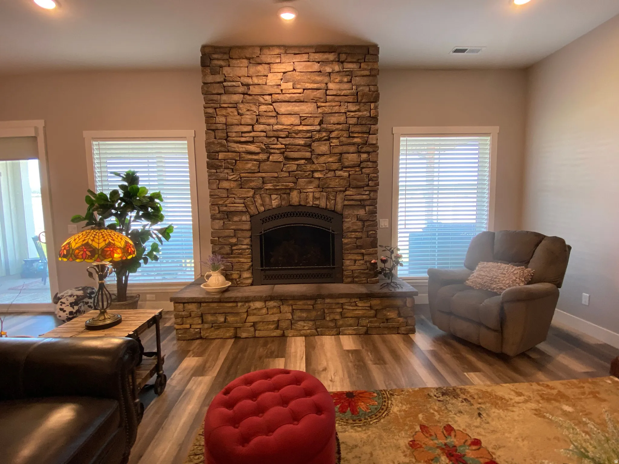 Living area with wood finished floors, a fireplace, recessed lighting, and plenty of natural light