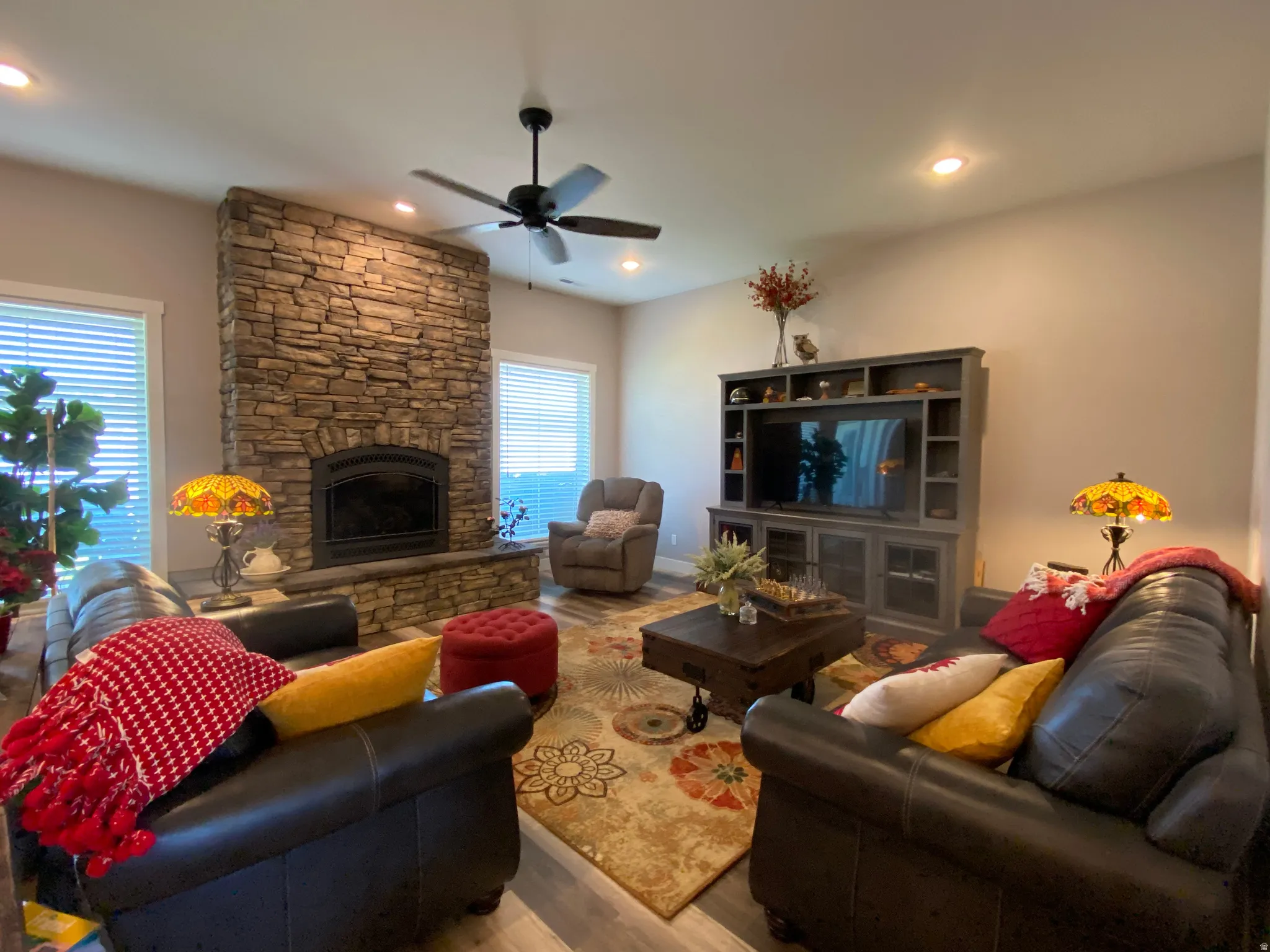 Living area featuring wood finished floors, a fireplace, a ceiling fan, and recessed lighting
