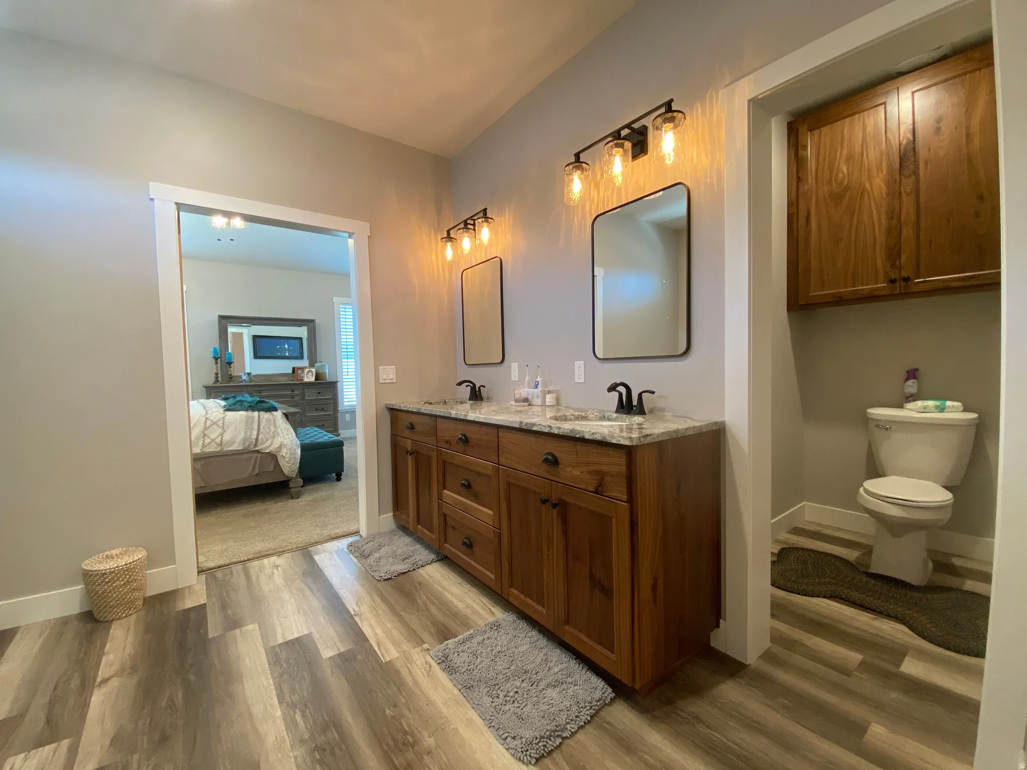 Ensuite bathroom with dark wood-style flooring and double vanity