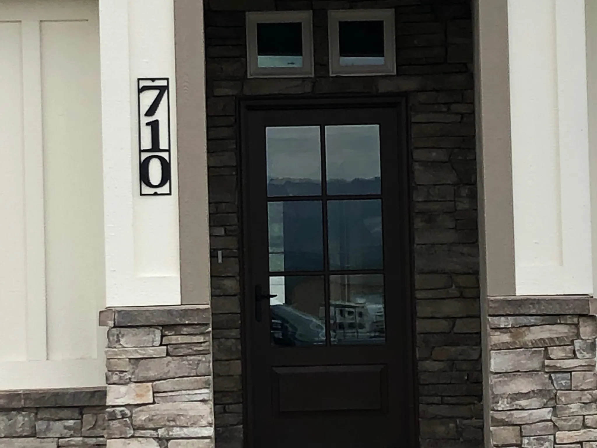 Entrance to property featuring stone siding
