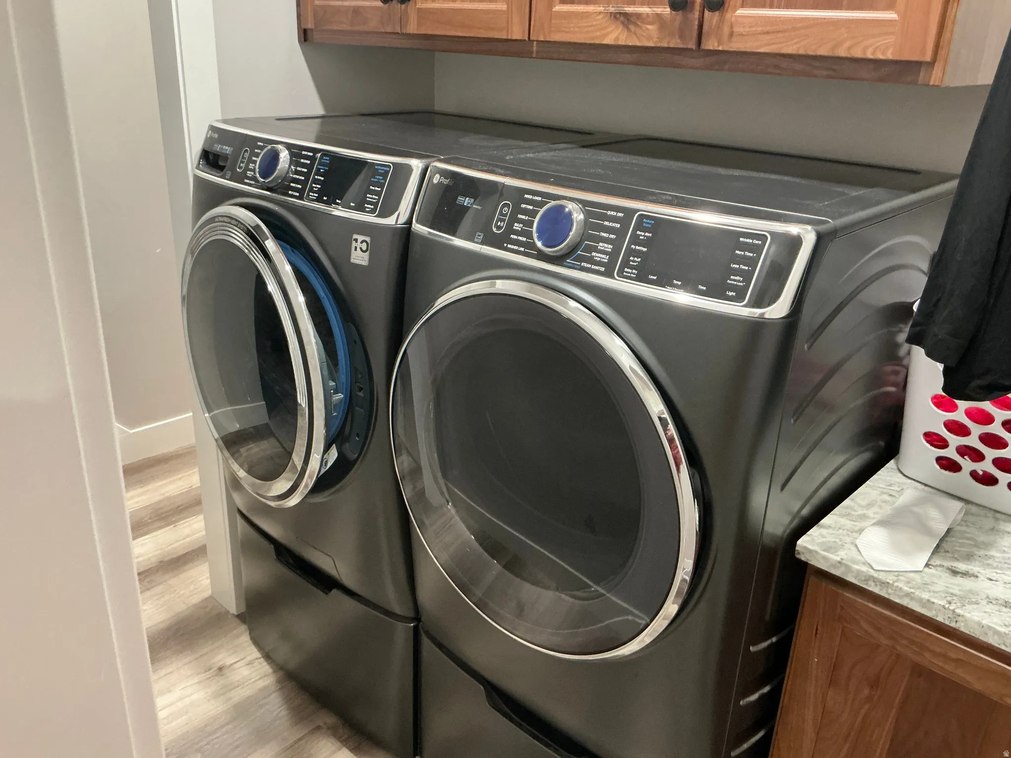 Laundry room with cabinet space, wood finished floors, and washer and clothes dryer