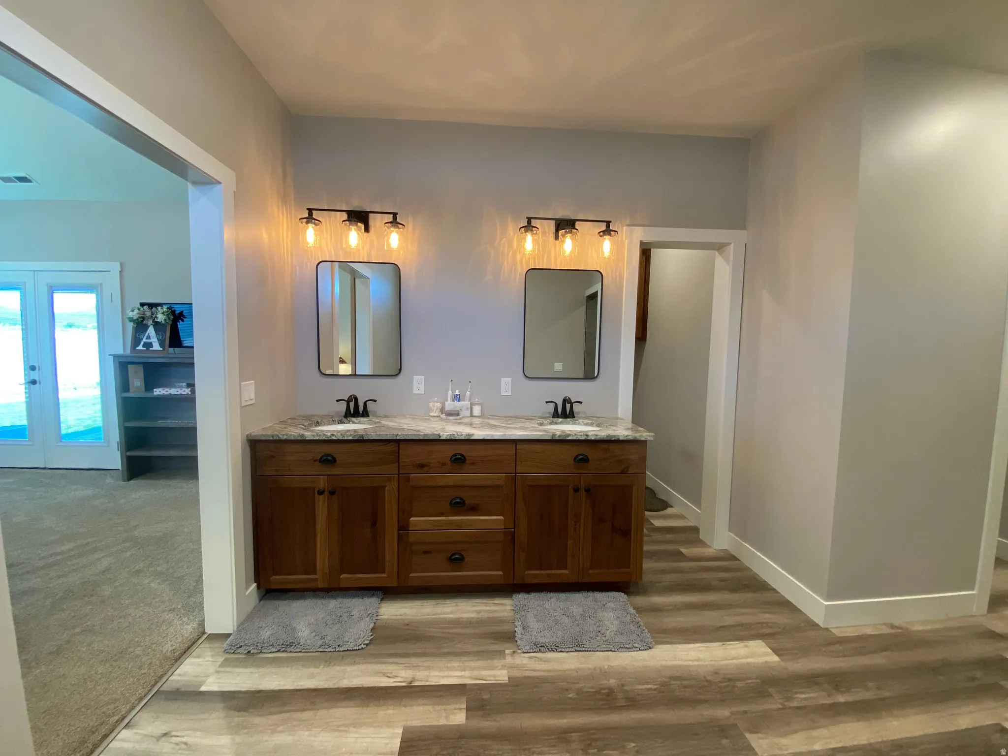 Bathroom featuring double vanity and light wood-style floors