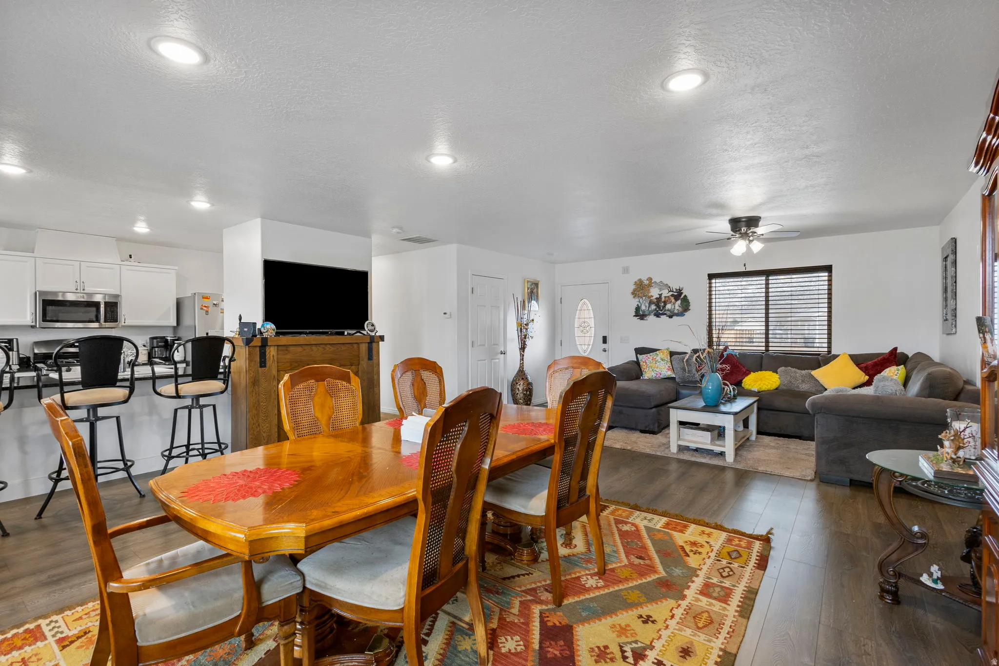 Dining space with wood-type flooring, ceiling fan, and a textured ceiling