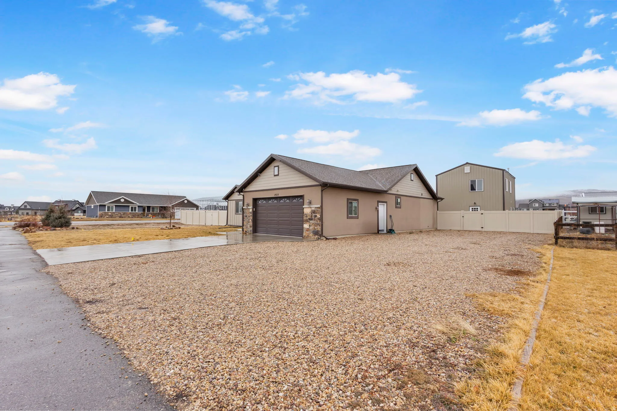 View of front facade with driveway, a residential view, and stone siding
