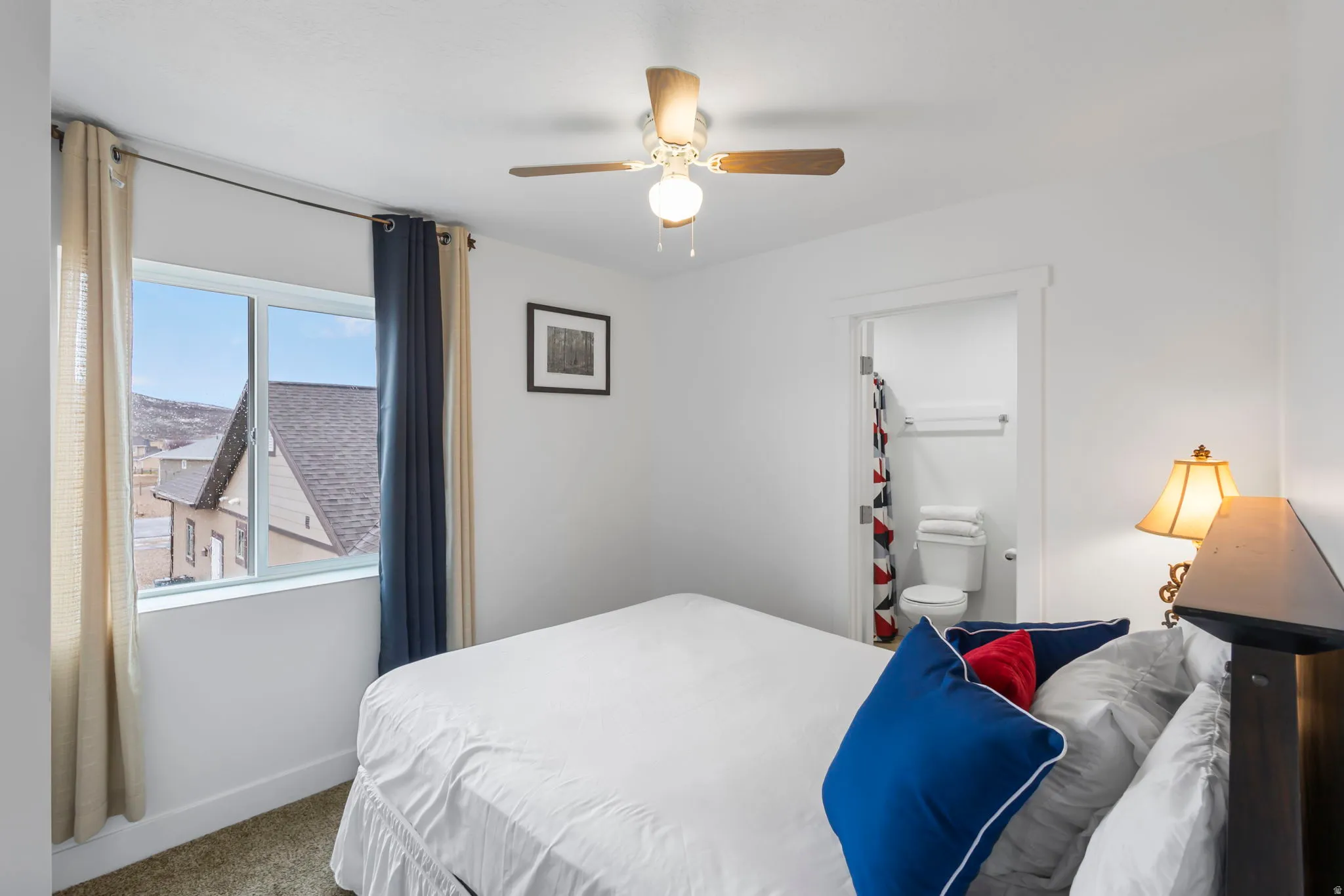 Bedroom featuring carpet flooring, ceiling fan, and ensuite bathroom