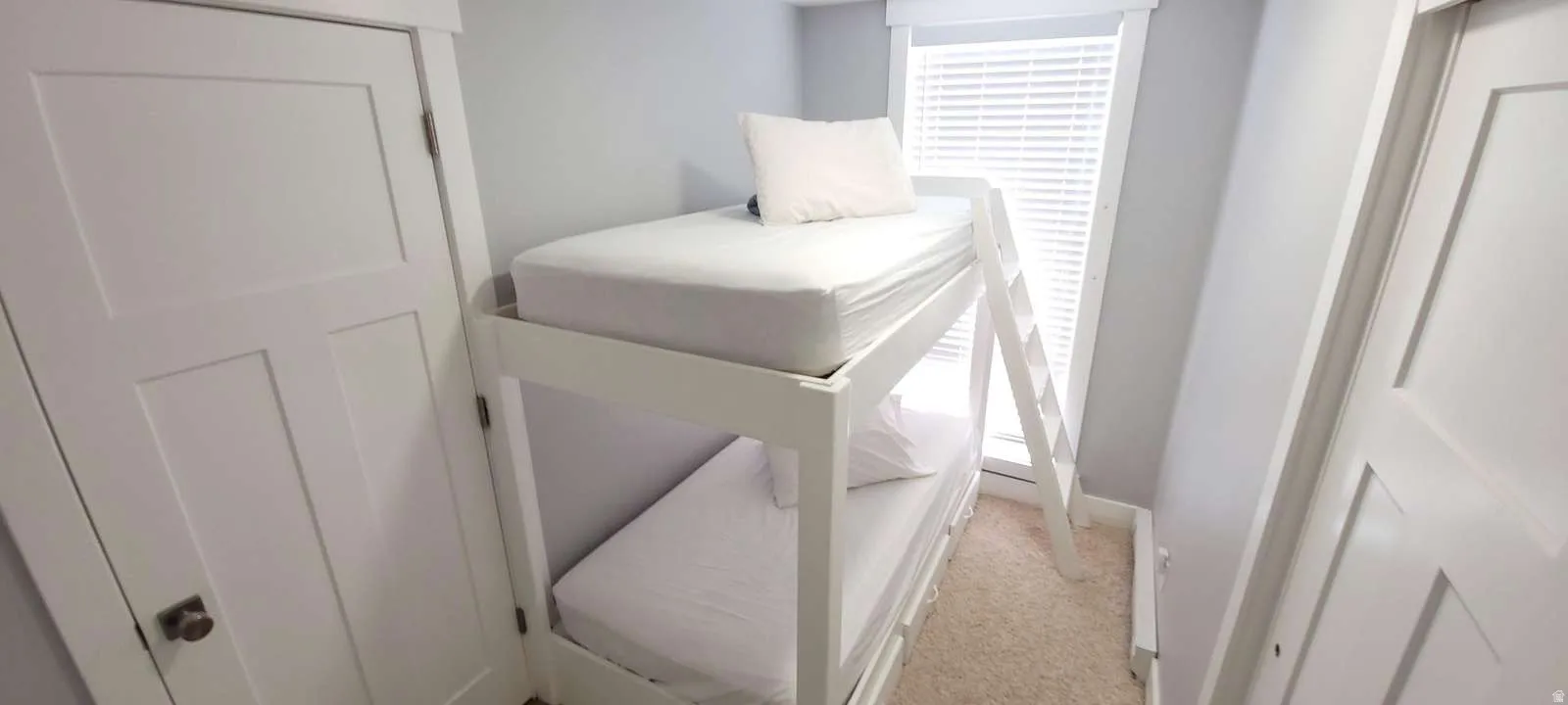 Bedroom with light carpet and a closet