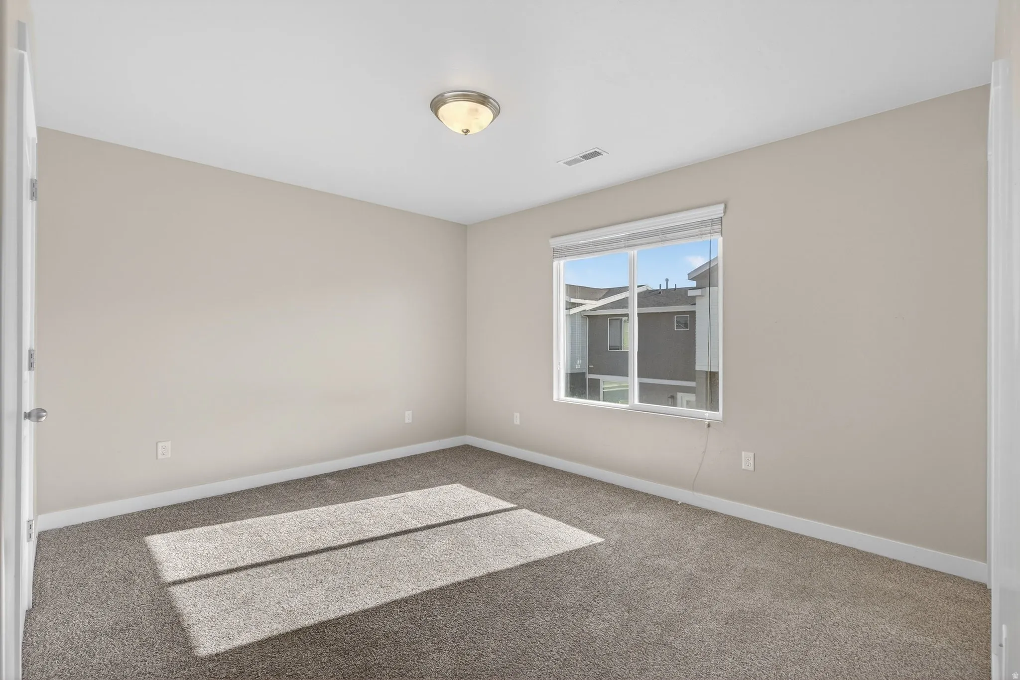 Empty room with carpet flooring and baseboards