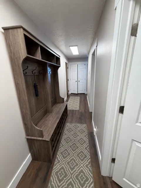 Mudroom with dark wood-type flooring and a textured ceiling