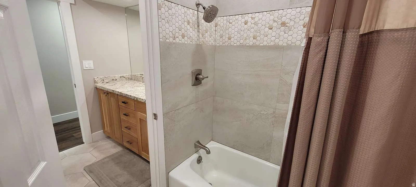 Full bath featuring shower / bath combo, light tile patterned floors, and vanity