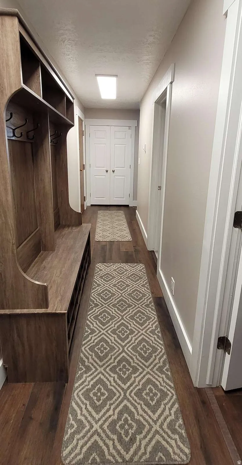 Mudroom featuring dark wood-style flooring and a textured ceiling