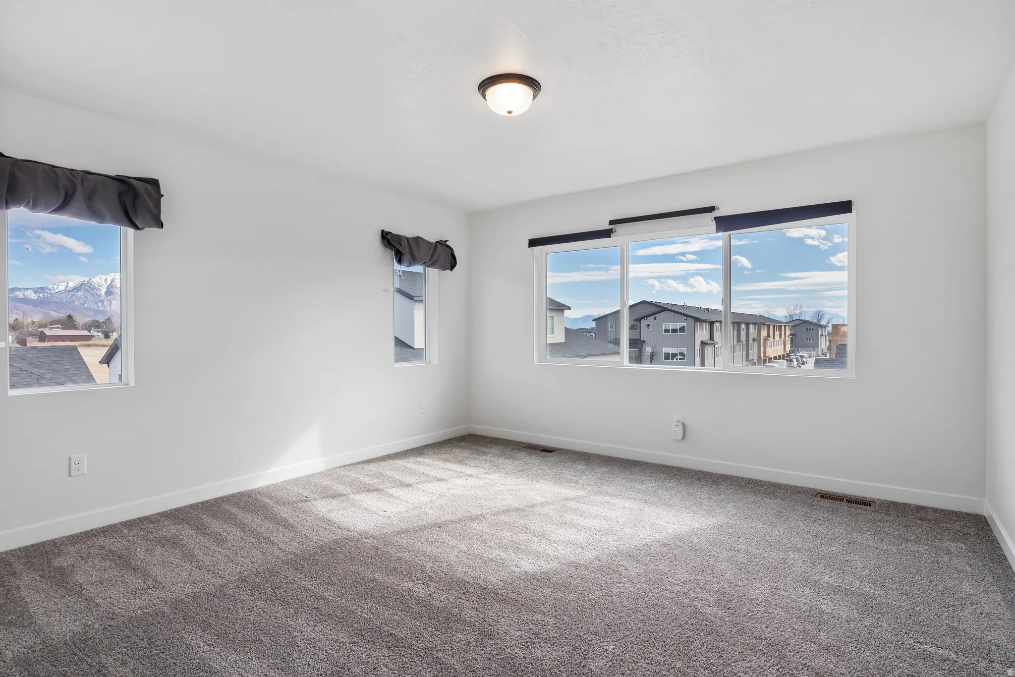 Carpeted spare room with healthy amount of natural light
