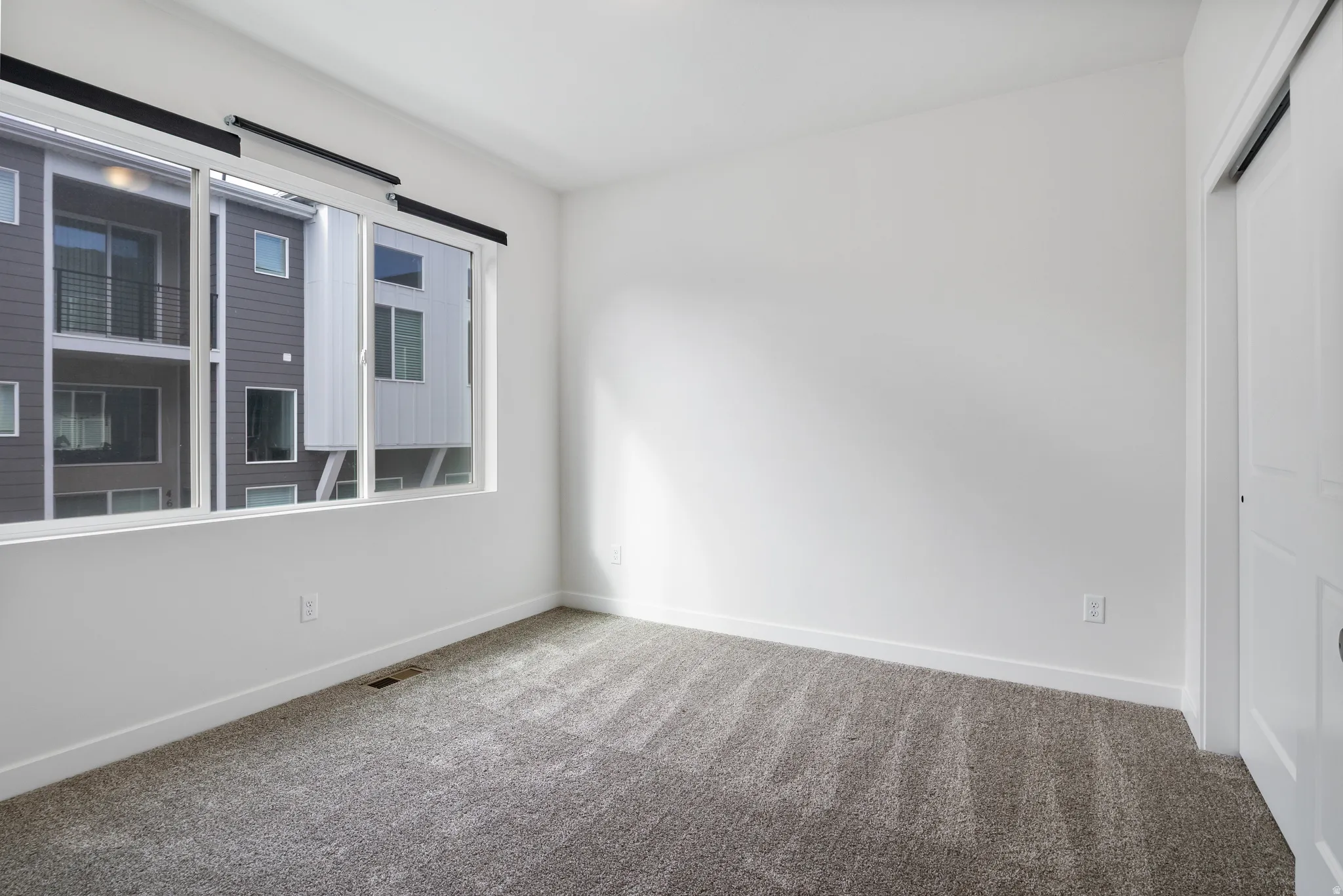 Unfurnished room with carpet and baseboards