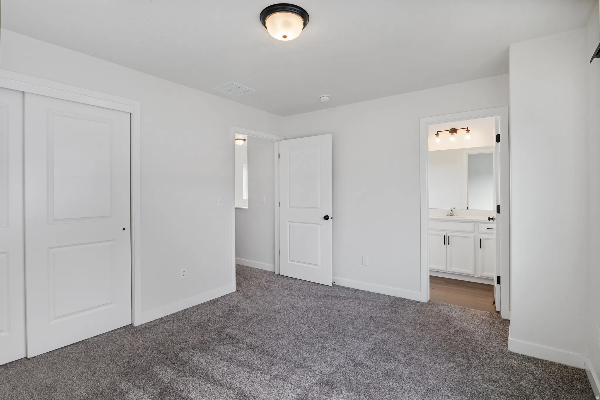 Unfurnished bedroom featuring dark carpet and a closet