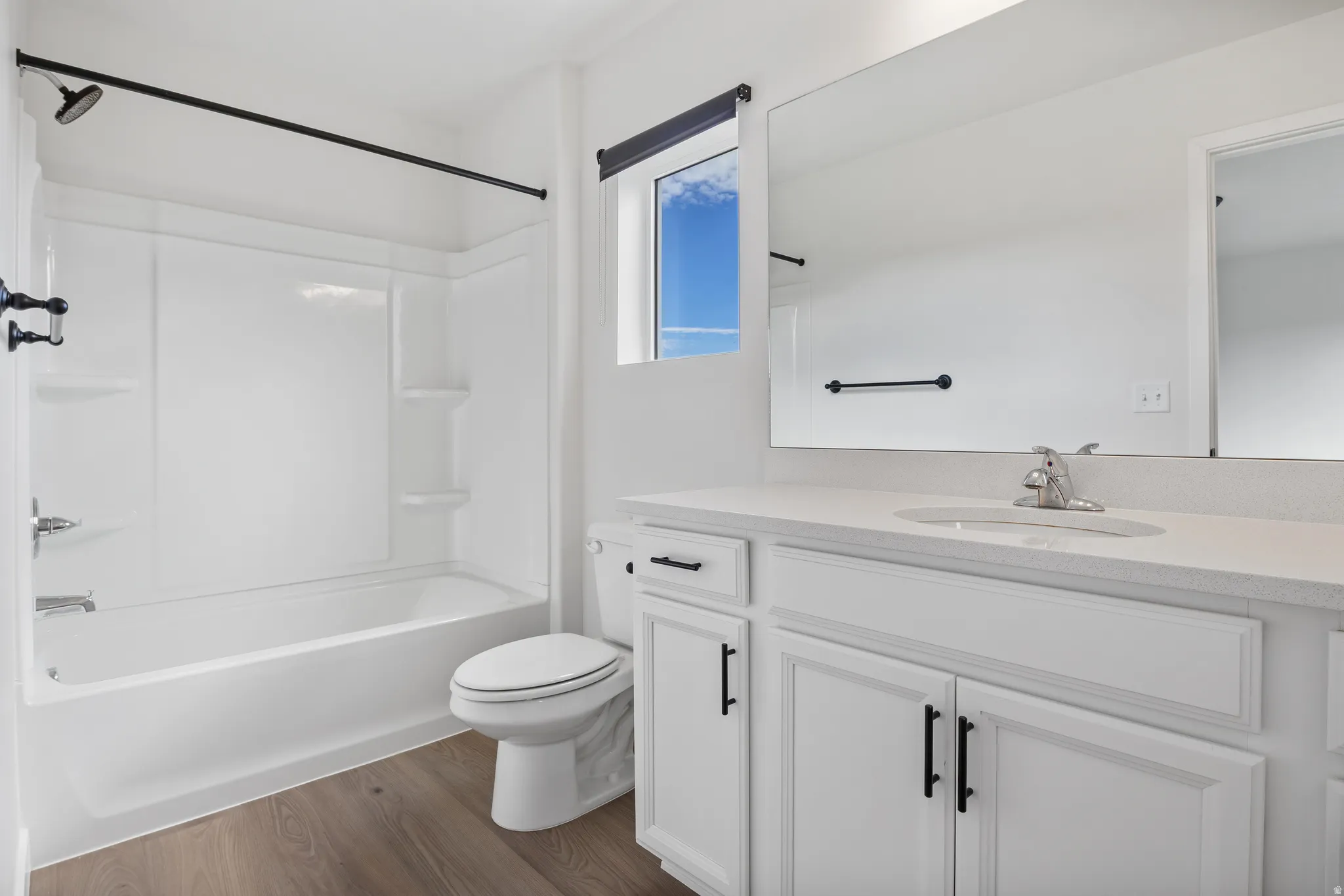 Full bathroom with vanity, dark wood-style floors, and tub / shower combination