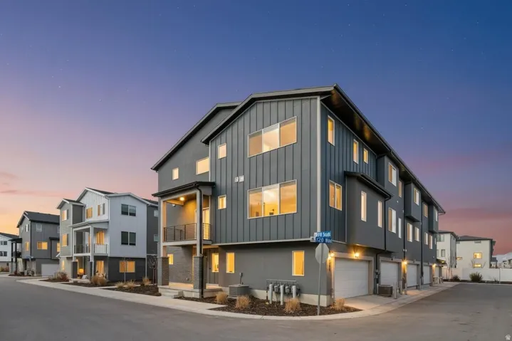 View of front of property featuring board and batten siding, a residential view, and an attached garage