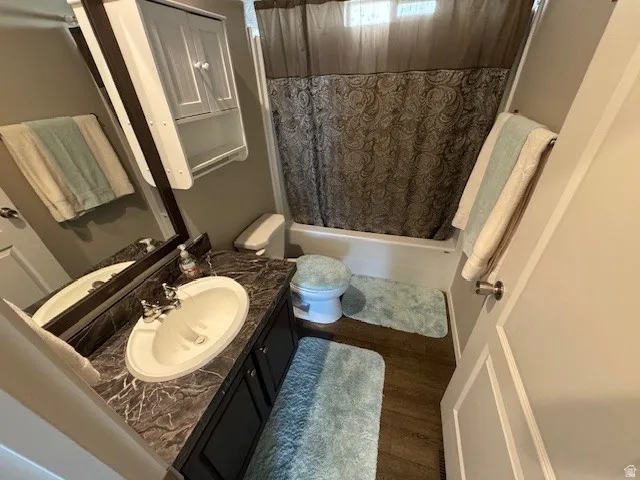 Full bath featuring vanity, dark wood-style floors, and shower / bath combo