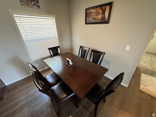 Dining area with dark wood finished floors and baseboards