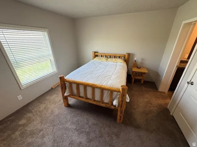 Bedroom featuring carpet and a textured ceiling