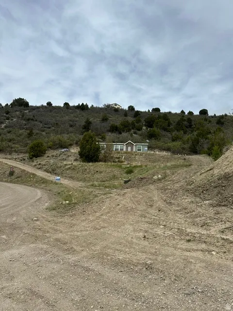 Hillside property featuring a light-colored structure and natural vegetation