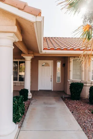 Entrance to property featuring a tiled roof and stucco siding