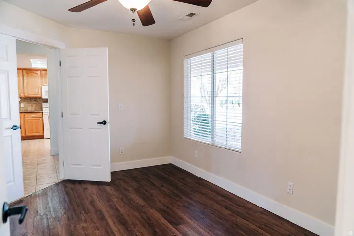 Spare room featuring a ceiling fan and dark wood finished floors
