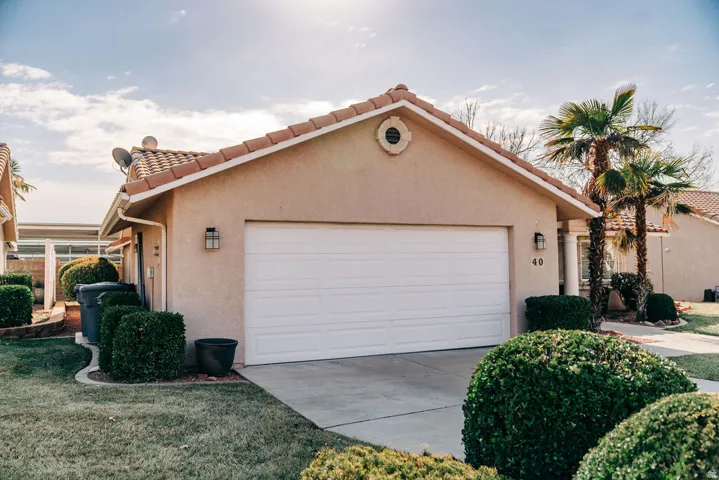 Mediterranean / spanish house with a tiled roof, stucco siding, a garage, and concrete driveway