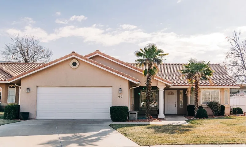 Mediterranean / spanish home with a tiled roof, stucco siding, driveway, and a garage