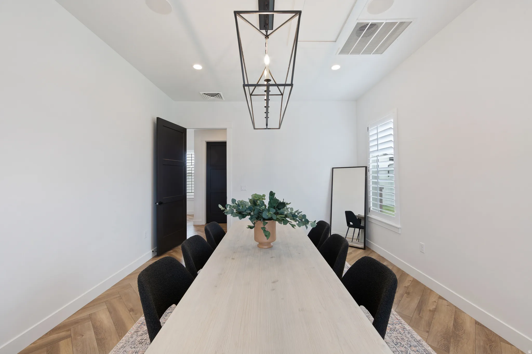 Dining area with light wood finished floors and recessed lighting