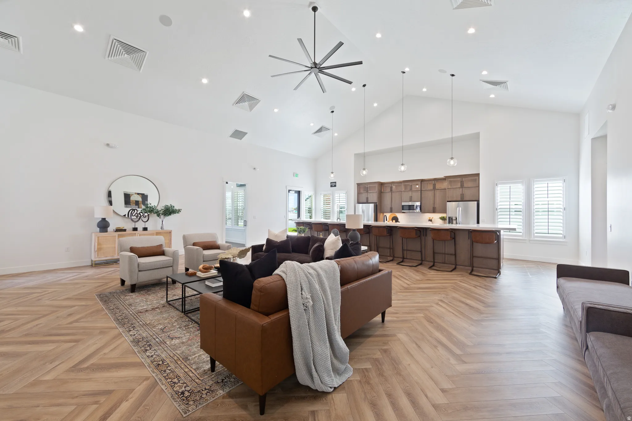 Living room featuring ceiling fan, parquet floors, and vaulted ceiling