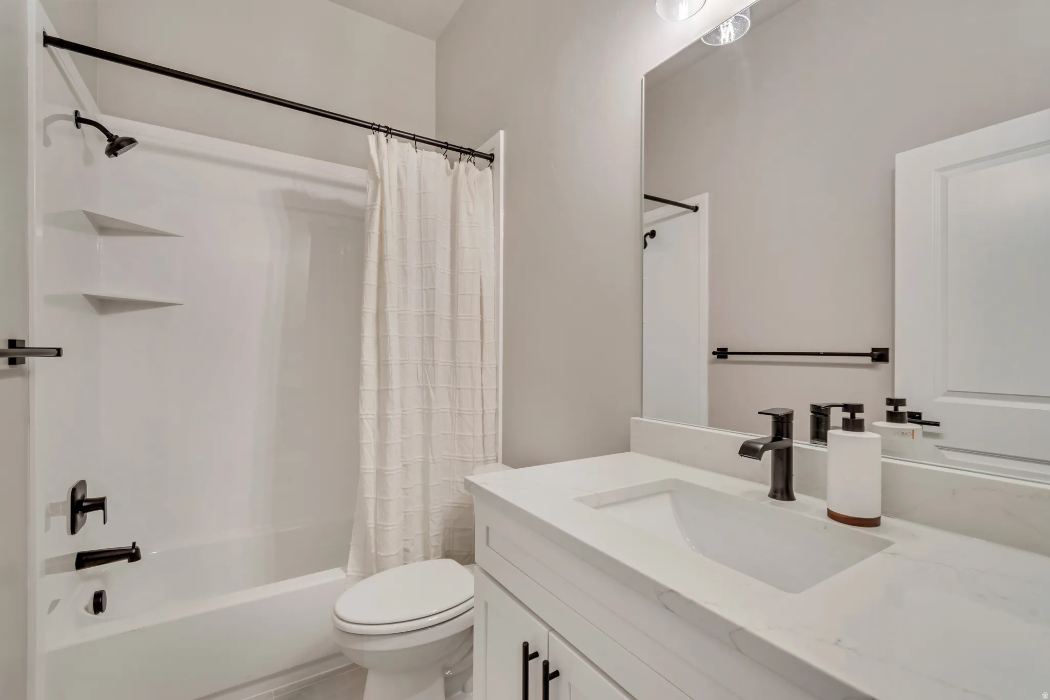 Full bathroom with shower / bath combo with shower curtain and vanity