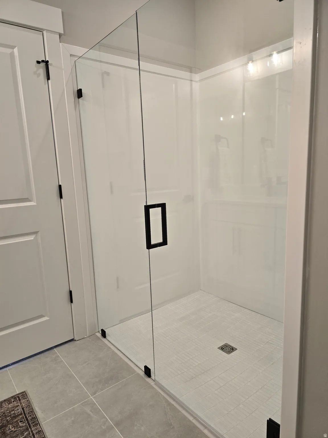 Full bath featuring a stall shower and tile patterned flooring