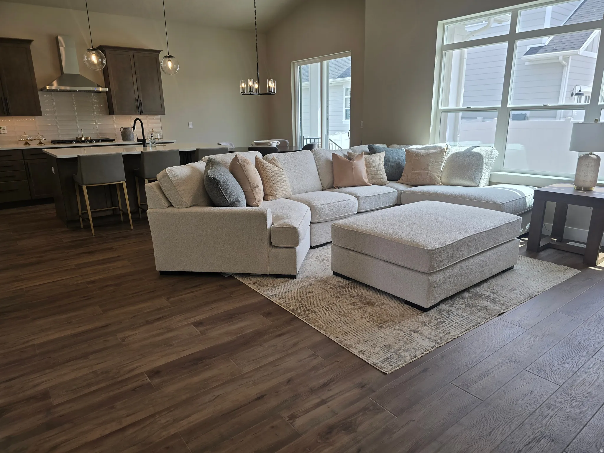 Living area featuring dark wood-type flooring, hanging lights, and lofted ceiling