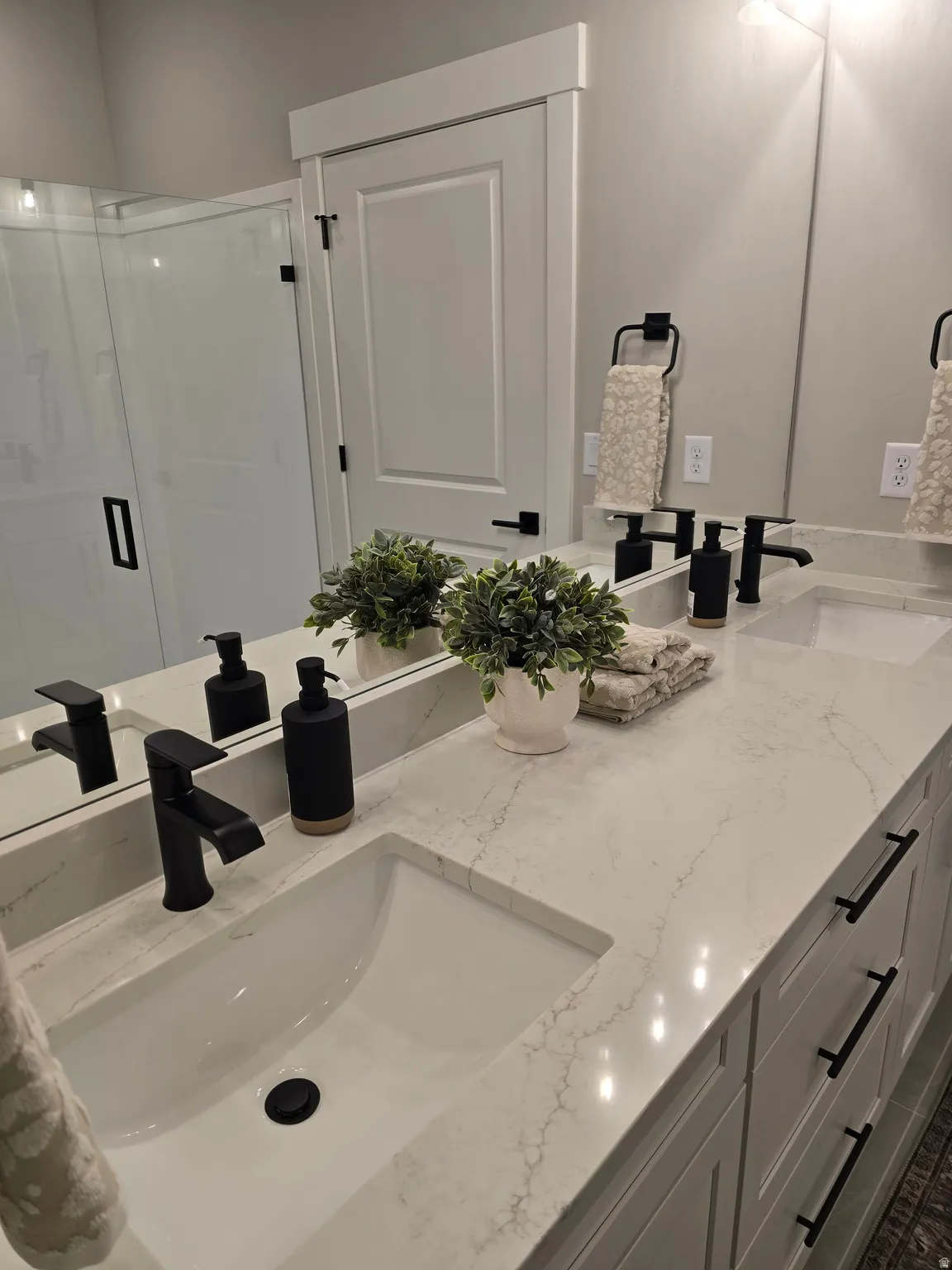 Bathroom featuring double vanity and a stall shower
